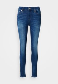 Sötét kék, skinny farmernadrág, klasszikus derékkal, öt zsebbel és finom kopással a lábak mentén.
