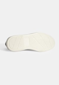 Witte rubberen zool met gestructureerde loopvlakken, gekenmerkt door een zigzag gripontwerp en een lichte kromming ter ondersteuning van de voetboog.