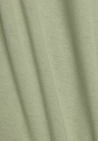 Tissu vert clair avec un tricot doux et texturé. Le matériau présente un motif diagonal subtil et une belle fluidité, adapté aux vêtements.