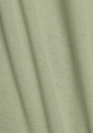 Vaaleanvihreä kangas, jossa on pehmeä, teksturoitu neule. Materiaalissa on hienovarainen viistokuvio ja sileä valuminen, joka sopii vaatteisiin.