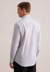 Camicia grigia a maniche lunghe con un motivo sottile, colletto aperto e polsini abbottonati. Presenta un orlo dritto e una texture liscia.