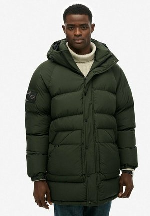 Dunkelgrüne Daunenjacke mit Reißverschluss und Knopfverschluss, ausgestattet mit Kapuze und seitlichen Taschen. Der Stoff wirkt glatt mit einem gesteppten Muster.