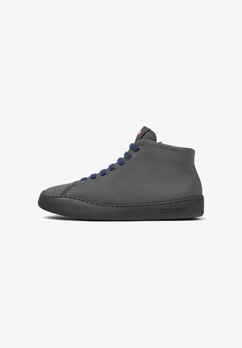 Zapatilla alta gris con cordones azules y suela negra, que presenta un diseño sencillo y un pequeño logo en el lateral. Vista lateral mostrada.