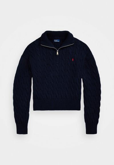 Navy cable-knit sweater with a half-zip collar, ribbed cuffs, and hem. Features a small red logo on the chest. Thick, textured fabric.