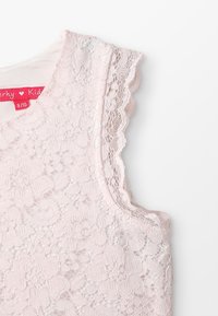 Lace roze top met bloemenpatronen, gegolfde randen en een ronde halslijn; etiket geeft maat 8/10 aan met kleurrijke branding.