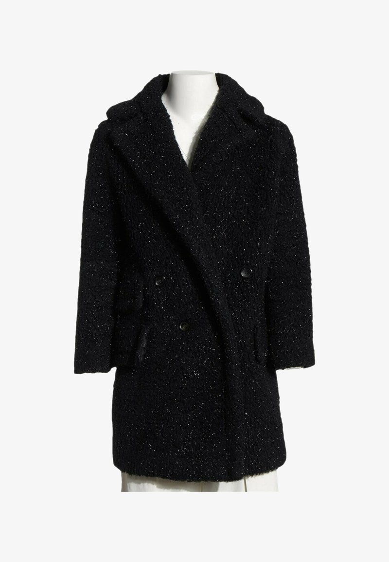 Manteau d'hiver noir texturé à double boutonnage avec larges revers et manches longues présenté sur un buste de mannequin blanc.