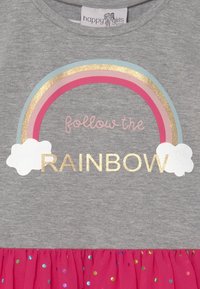 Šedé šaty s duhovým motivem obsahujícím růžové, modré a zlaté akcenty. Sukně je růžová s barevnými puntíky, vyrobená z měkké látky.