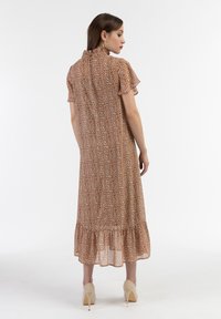 Rochie midi brun cu flori, cu guler înalt, mânecile scurte cu volănașe și tiv în straturi. Confecționată dintr-un material ușor, cu o textură fluidă.
