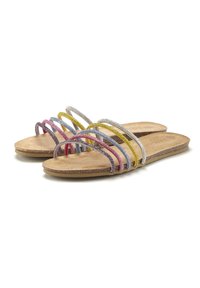 Sandali piatti con numerose cinghie colorate in rosa, giallo, blu e argento, poggiati su una soletta in sughero naturale.