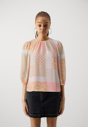 Blus med blommönster och geometriska mönster, med puffärmar, i pastellfärger som rosa och kräm, tillverkad av lättviktsmaterial.