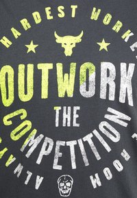 Camiseta gris con texto en blanco y amarillo neón, en un estilo audaz y texturizado. El diseño incluye un cráneo de vaca y estrellas, promoviendo un mensaje motivacional.