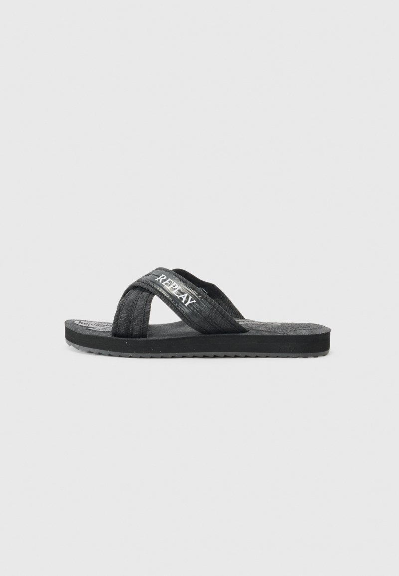 Black flip-flop sandal with textured fabric straps, smooth rubber sole, and embossed logo detail on the insole. Designed for casual wear.