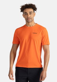 Krátký rukáv oranžové sportovní tričko, vyrobené z lehkého materiálu, s kulatým výstřihem a černým logem značky na hrudi.