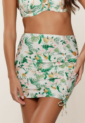 Floral mini skirt featuring a tropical print with green leaves and pink flowers, drawstring side detail, and textured fabric.