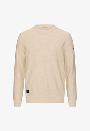 Beiger Pullover mit Rundhalsausschnitt und langen Ärmeln, mit gerippten Bündchen und Saum, versehen mit kleinen schwarzen Markenaufnähern vorne unten und am linken Ärmel.