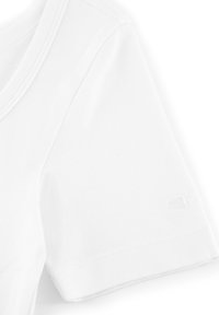 T-shirt in cotone bianco con scollatura rotonda, maniche corte e orlo cucito. Presenta un piccolo logo ricamato sulla manica.
