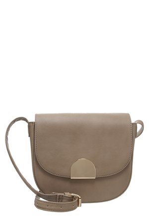 Sac bandoulière en cuir taupe avec rabat courbé et fermoir en demi-cercle doré, sangle réglable avec boucle, design minimaliste.