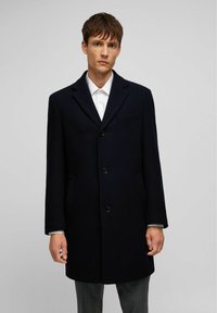Dunkelblauer Wollmantel mit klassischem Design, ausgestattet mit einem Reverskragen, drei Knöpfen, seitlichen Taschen und einer einzigen Brusttasche.