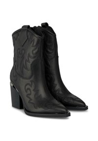 Botas de cuero negras hasta el tobillo con punta afilada, que cuentan con patrones de costura decorativos, tacones apilados y lengüetas para ponerlas y quitarlas con facilidad.