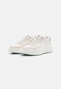 Zapatillas blancas que combinan materiales lisos y texturizados, con una suela gruesa, un diseño en capas y sutiles acentos en tonos pastel.