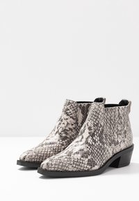 Schlangenleder-musterte Stiefeletten in Grau und Schwarz, mit spitzem Zeh und niedrigem Blockabsatz. Strukturierten Oberfläche mit elastischen Seitenpanele.