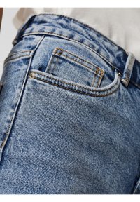 Ljusblå denimjeans med en slät yta, synliga sömmar, en bakficka och en klassisk passform.