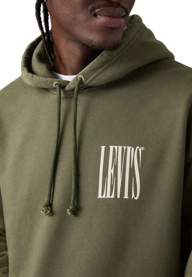 Hombre con sudadera con capucha de color verde oliva con cordones, con el logo blanco "LEVI'S" en el pecho, sobre un fondo liso.