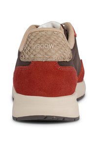Brązowy sneaker z czerwonym zamszem i teksturowanym, beżowym obcasem. Charakteryzuje się wyściełanym kołnierzem i miękkim materiałem wewnętrznym. Logo "WODEN" na pięcie.