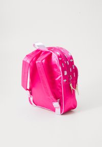 Rózsaszín nylon hátizsák, két párnázott vállpánttal, cipzáros zárással, és színes nyomott mintákkal különböző formákban az egyik oldalon.