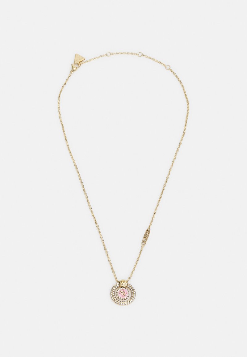 Gouden ketting met een ronde hanger met een roze middenstuk en heldere strassaccenten in concentrische cirkels. Textuurdetails op de hardware.