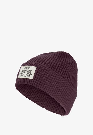 Beanie viola in maglia con texture a costine e risvolto, caratterizzato da una toppa rettangolare bianca con la scritta "JACK WOLFSKIN" e grafiche di montagne.
