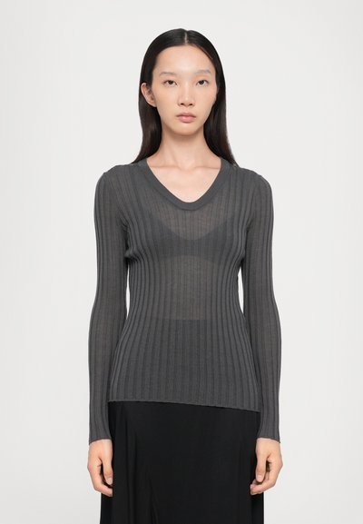 Maglione grigio a maniche lunghe con scollo a V. Materiale trasparente con design aderente, texture contrastante e orlo leggermente irregolare.