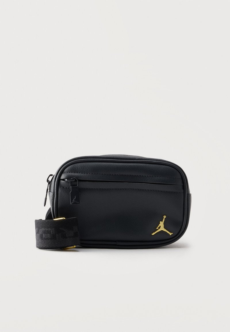 Μαύρο ορθογώνιο τσαντάκι χιαστί με μπροστινή τσέπη με φερμουάρ, ρυθμιζόμενο λουρί και χρυσό λογότυπο Jumpman στην κάτω δεξιά γωνία.