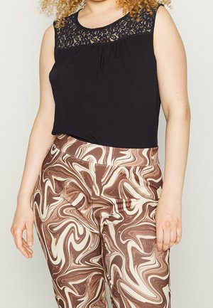 Ärmelloses schwarzes Top mit Spitzenakzent, kombiniert mit hoch taillierten Hosen mit braunem und cremefarbenem Wirbelmuster.