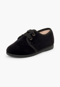 Chaussure en tissu noir souple avec des lacets façon ruban, semelle basse et bout arrondi, vue légèrement de côté sur fond blanc.