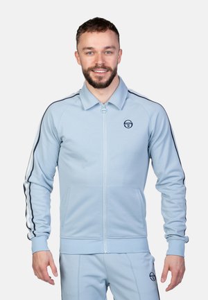 Lichtblauwe zip-up jas met kraag, voorzien van zwarte zijkanten en een logo. Slim fit met ribgebreide manchetten en zakken.