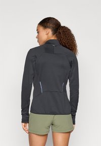 Μαύρο μπουφάν με μακριά μανίκια και ψηλό λαιμό, με υφή, ανοιχτό μπλε λεπτομέρειες στα πλαϊνά και εφαρμοστή σχεδίαση.