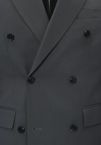 Tumehall tikkidega kahe nööbiga bleiser, kuus musta nuppu ja kaks küljetaskut. Omab teravaid krae ja voolavat lõiget.