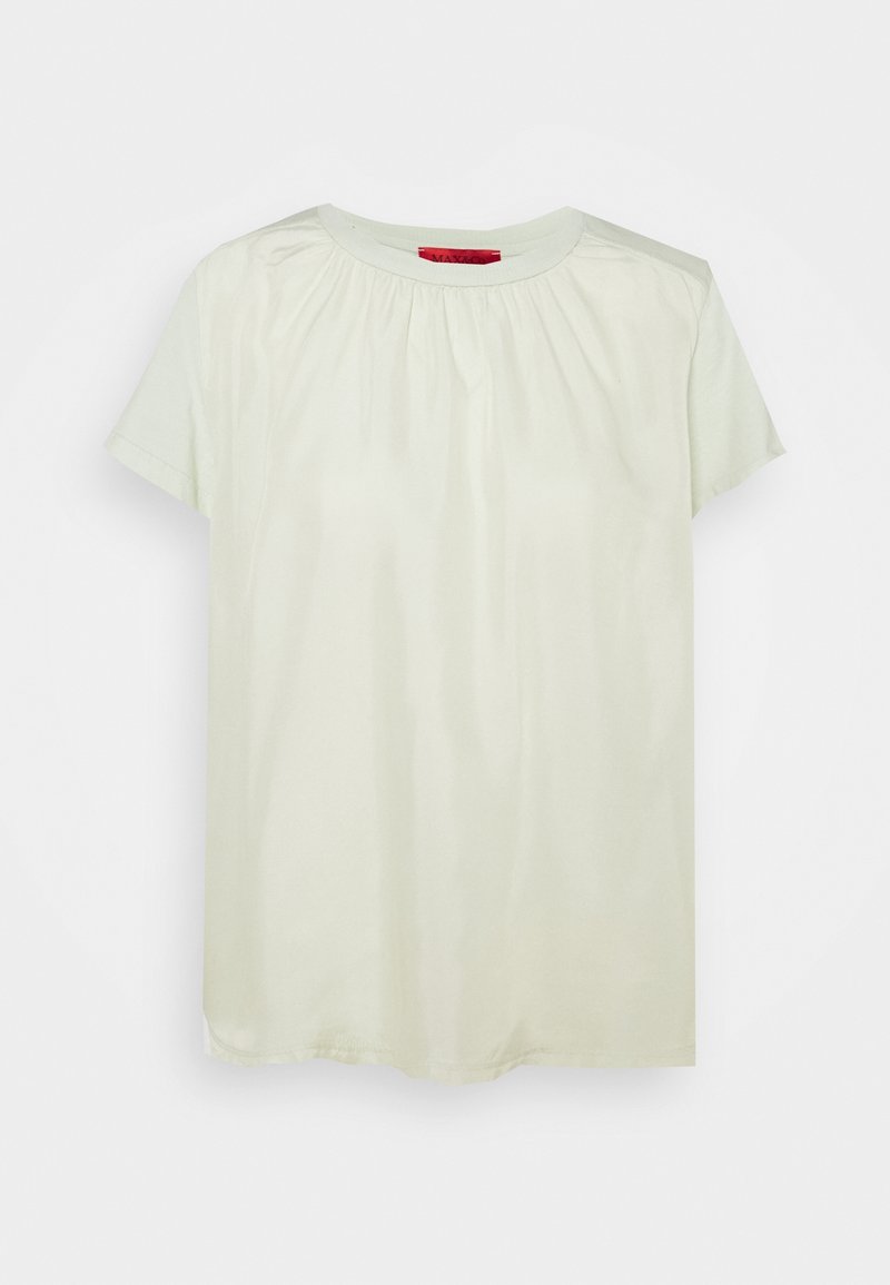 Blouse crème à manches courtes avec détail froncé au niveau de l'encolure et col rond, présentée sur un fond clair uni.