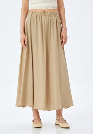 Jupe maxi beige fluide avec une ceinture élastique, fabriquée en matériau doux. L'ourlet est droit, offrant une coupe décontractée et un tomber sans couture.