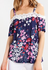 Navy floral blouse with off-shoulder design, featuring white lace trim. Patterns include red and pink flowers on a dark background. Short sleeves.