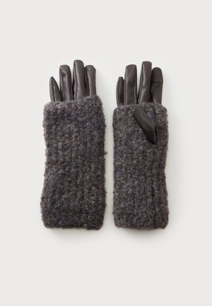 Par de guantes gris oscuro con dedos de cuero y puños tejidos peludos, colocados planos con las palmas hacia abajo sobre un fondo blanco.