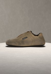 Ταμπά δερμάτινο παπούτσι τύπου slip-on με μαύρη σόλα και ελαστικό περίγραμμα, με μια μικρή μαύρη ετικέτα με λευκό κείμενο "Rombaut" στη πλευρά.