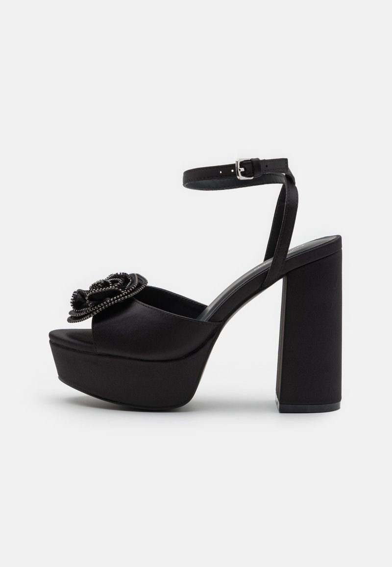 Fekete platform szandál, selyemből készült, vastag tömbsarokkal, állítható bokapánttal és virágos gyöngyökkel díszítve az orrán.