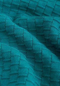 Türkisfarbener Strickstoff mit einem strukturierten, gewebten Karomuster. Weiche Textur, mit erhöhten Quadraten, die Tiefe und visuelles Interesse erzeugen.