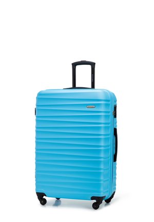 Maleta rígida azul con textura de ondas, asa negra retráctil, asa lateral y cuatro ruedas negras.