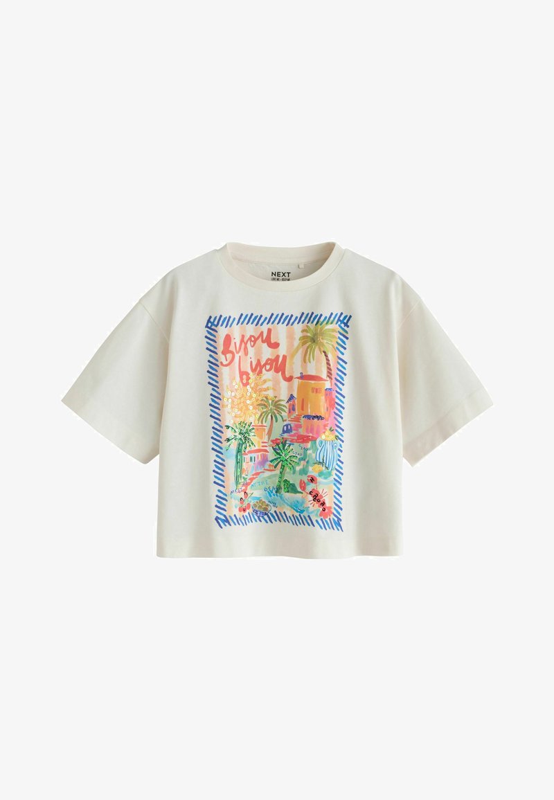 T-shirt court à manches courtes blanc avec imprimé tropical coloré représentant des palmiers, des bâtiments et un texte rouge « Bisou bisou » encadré par des bandes bleues.
