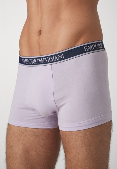 Levendula színű pamut boxer alsónemű, sötétkék elasztikus derékkal, amelyen az "EMPORIO ARMANI" logó található. Simább textúrájú és illeszkedő fazonú.