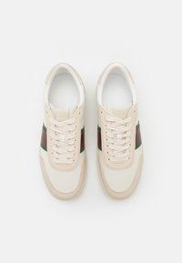 Sneakers stringati in pelle crema e beige, con strisce orizzontali verdi e marroni. Punta rotonda e suola in gomma texture.