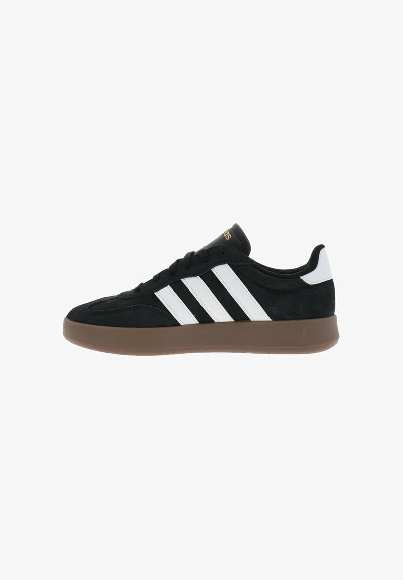 Sneaker in suede nero con tre strisce bianche sul lato, suola in gomma marrone e lacci neri. Presenta un colletto imbottito e un logo dorato.